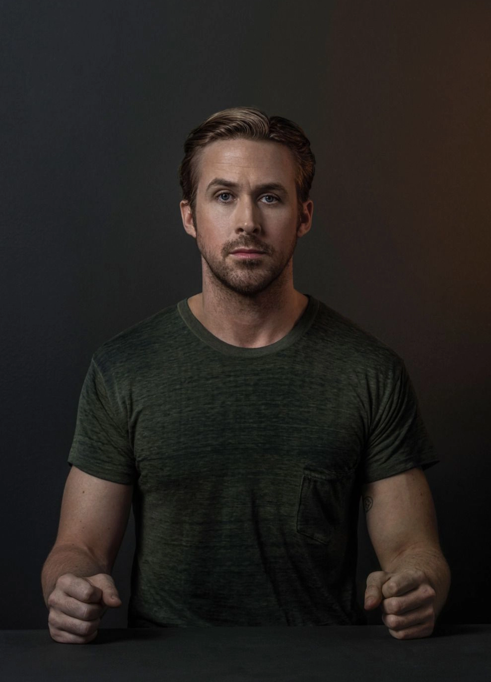 Ryan Gosling with Clenched Fists at Table